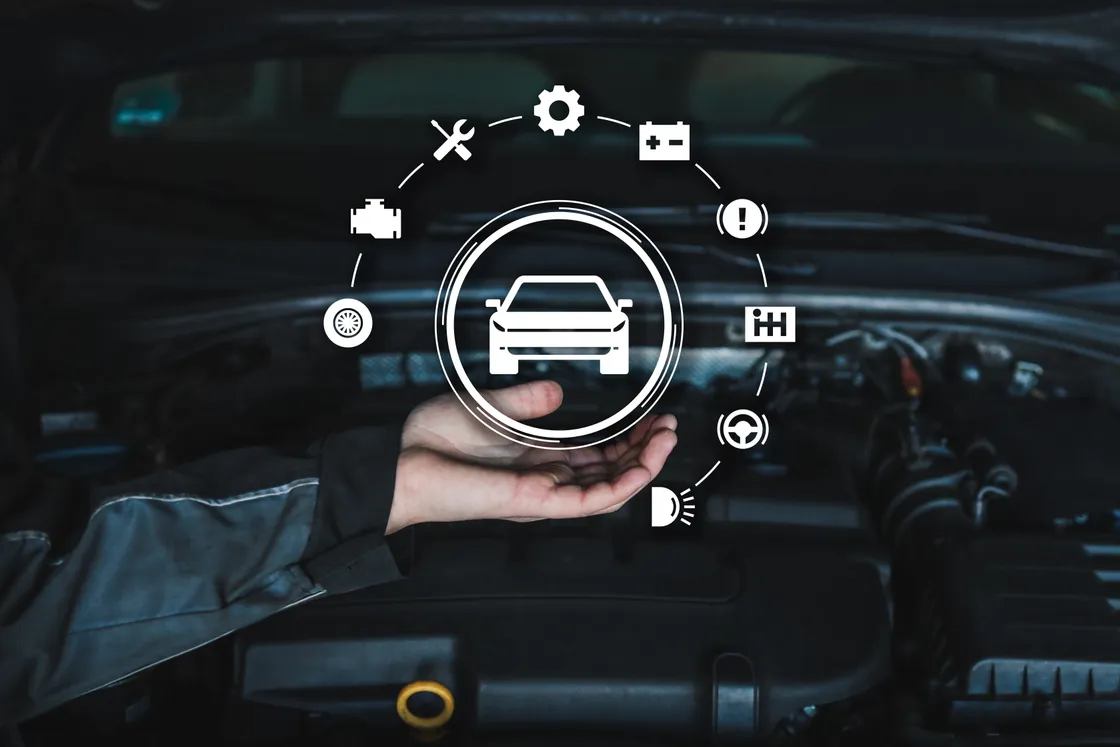 A technician's open hand beneath a vehicle icon ringed by service symbols, over an open engine bay.